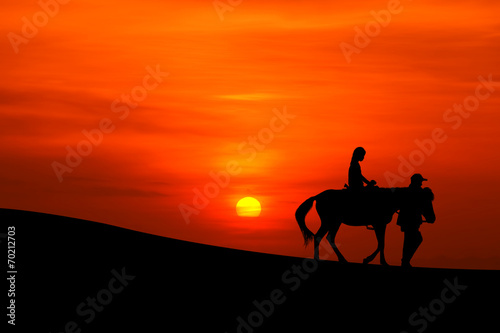 sillhouette of a journey on horseback with sunset