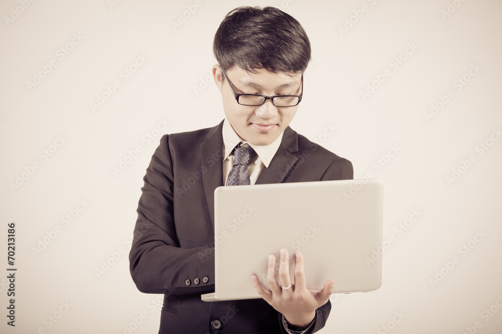 Asian business man using laptop computer isolated on white backg