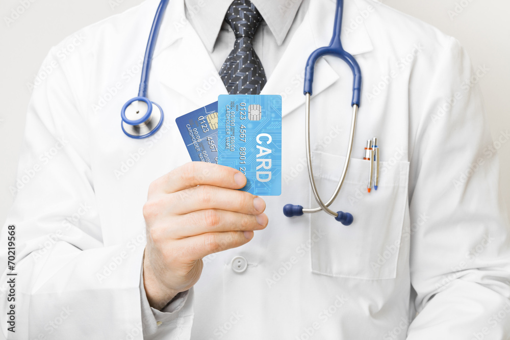 Doctor holding credit cards in his hand - closeup studio shot
