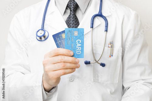 Obraz na płótnie Doctor holding credit cards in his hand - closeup studio shot w salonie
