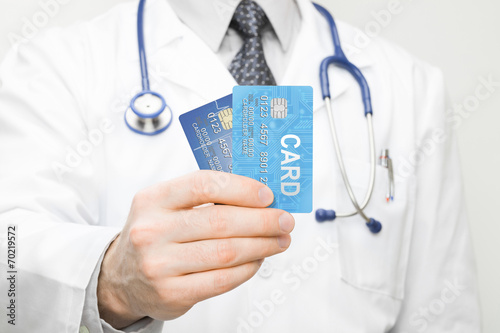 Doctor holding two credit cards in his hand