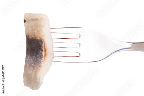 Fork with a piece of herring isolated on white background photo