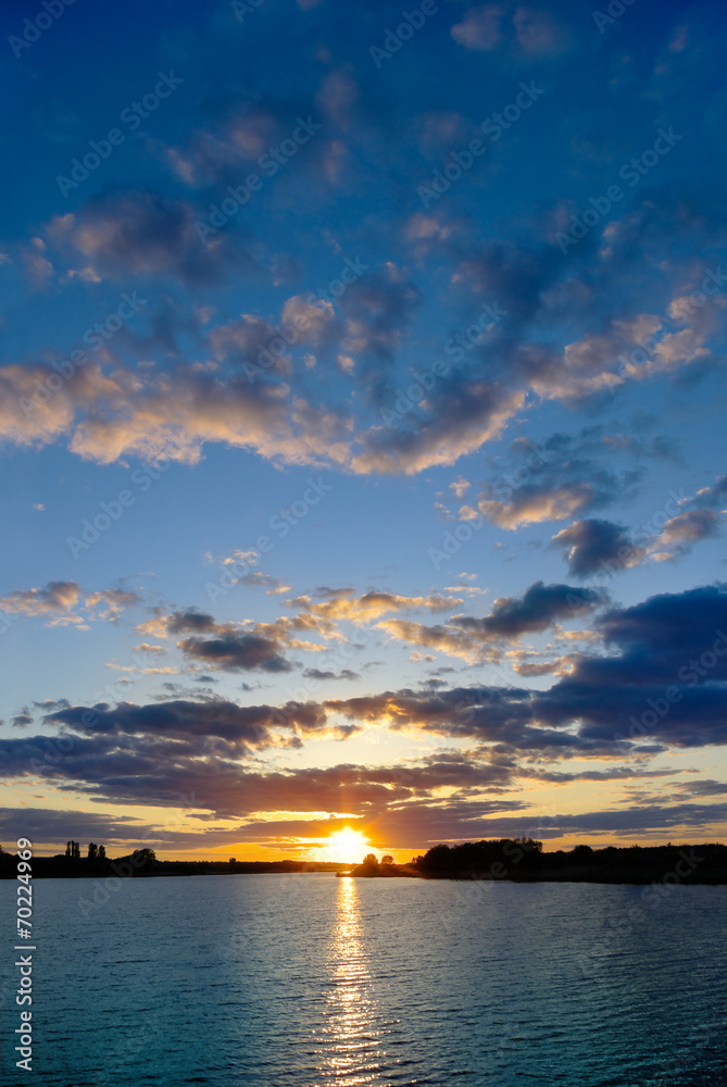 Sunset over the lake on a background of blue sky Sunset over the lake on a background of blue sky