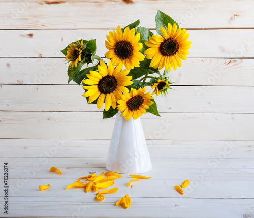 Fototapeta Naklejka Na Ścianę i Meble -  Sunflowers in a vase on a rustic, gray background