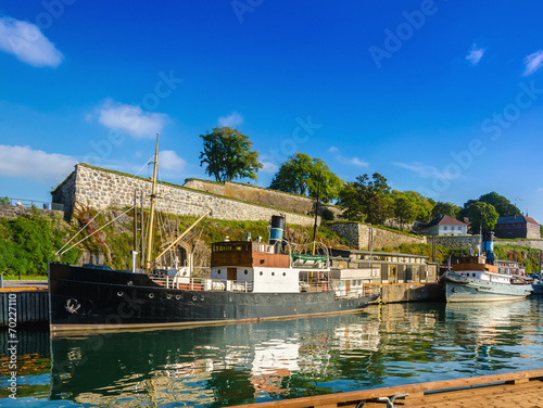 Salmon fishing boat in  harbor of Oslo fjord with Askershus fort photo