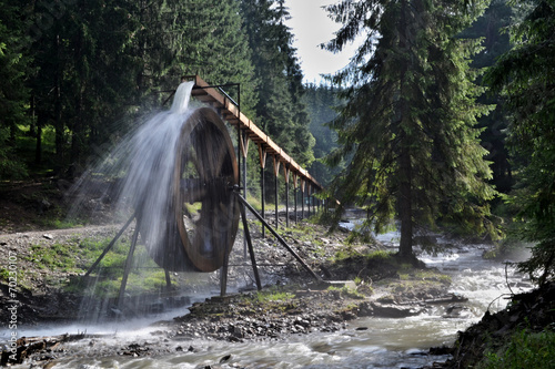 Rodna mountains in Romania - water wheel at Iza river source photo