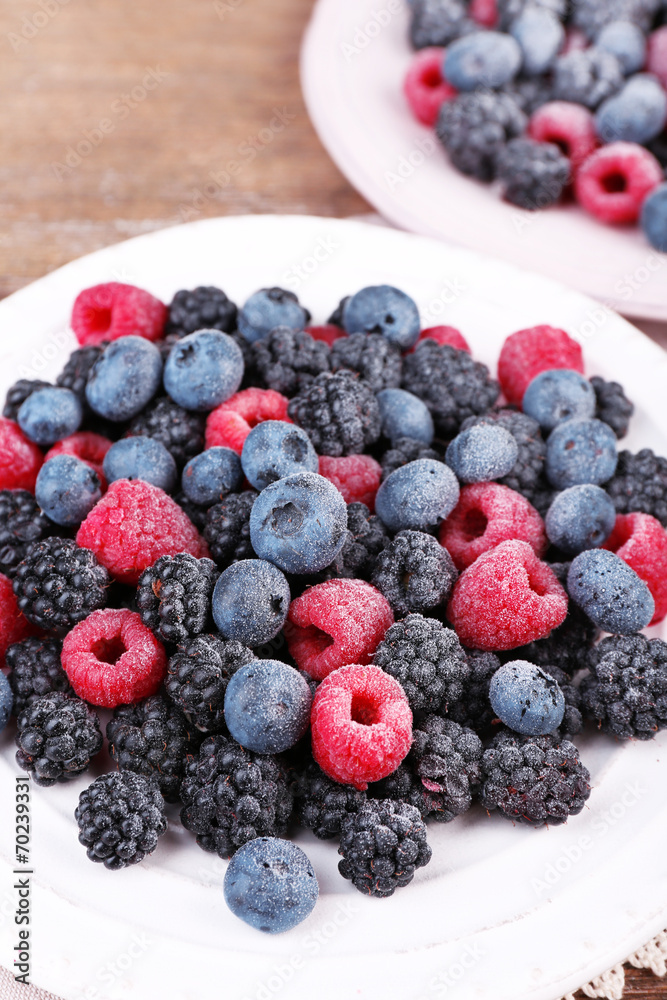 Iced berries on plates, on wooden background Iced berries on plates, on wooden background