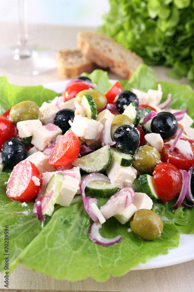 Greek salad in plate served on napkin on wooden background Greek salad in plate served on napkin on wooden background