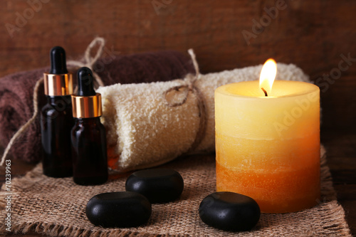 Spa stones, oil and candles on wooden background