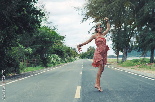 Young himmpe girl dancing on a road at a summer day