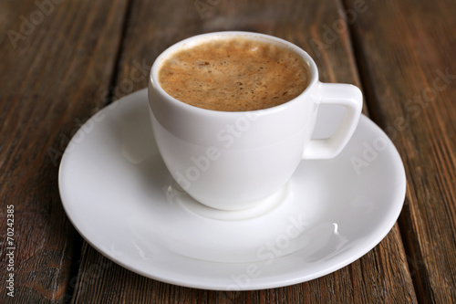 Cup of coffee with milk on wooden background
