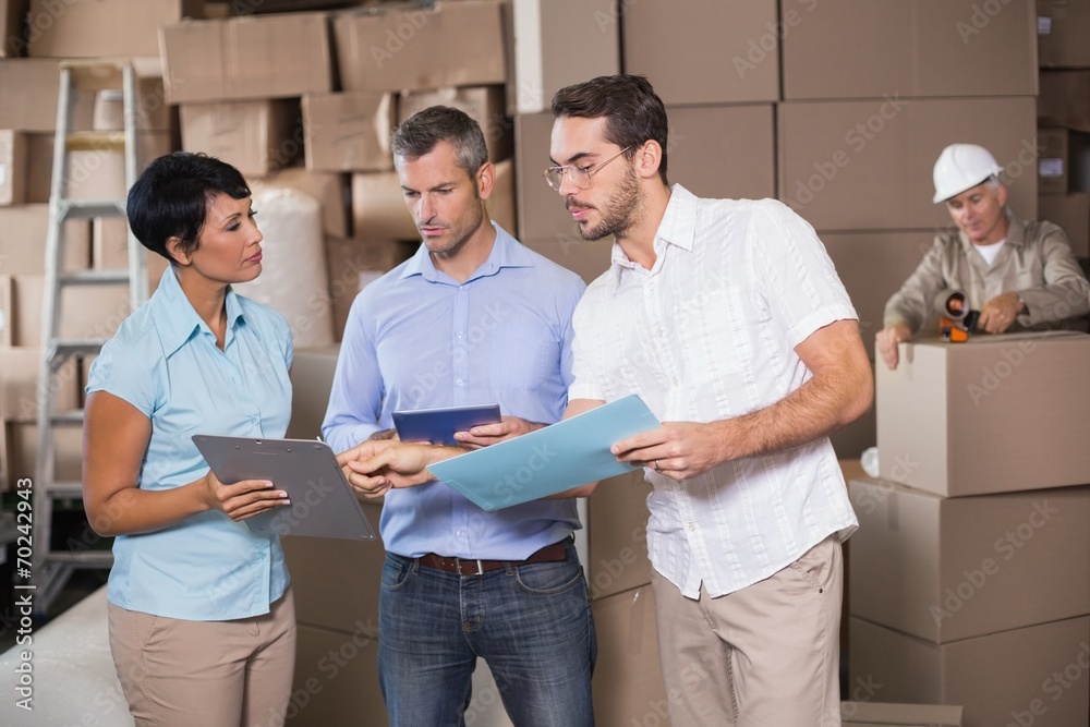 Warehouse workers talking together at work Warehouse workers talking together at work