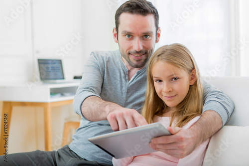Father and his blond daughter using tablet