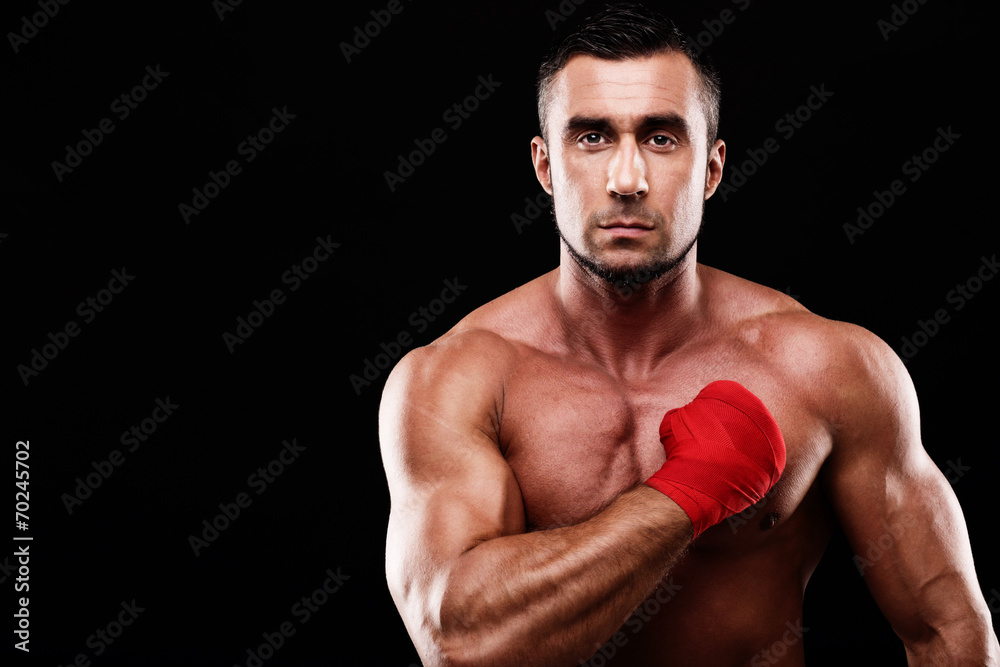 Portrait of a handsome sportsman on black background