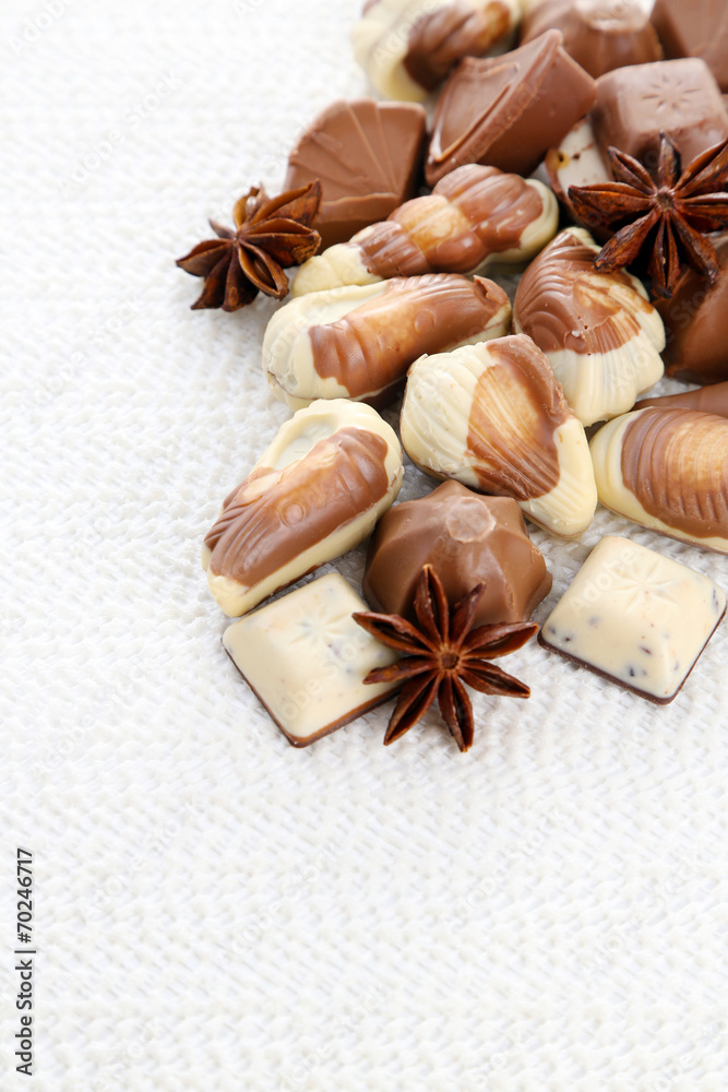 Different kinds of chocolates with spices on white background