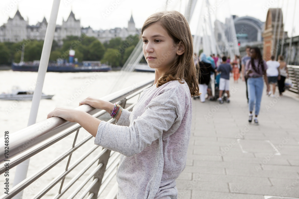 Fototapeta premium Side view portrait of pensive teenager girl standing on bridge