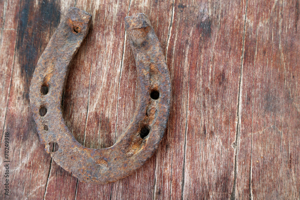 Old horse shoe on wooden background Old horse shoe on wooden background