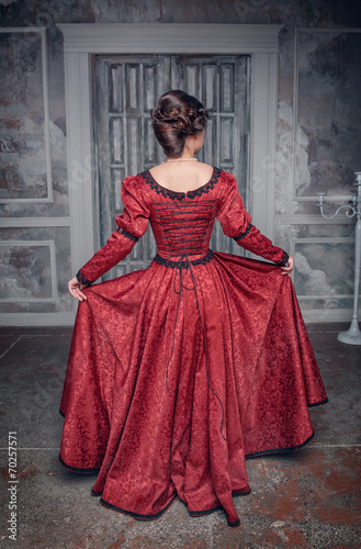 Beautiful medieval woman in red dress, back