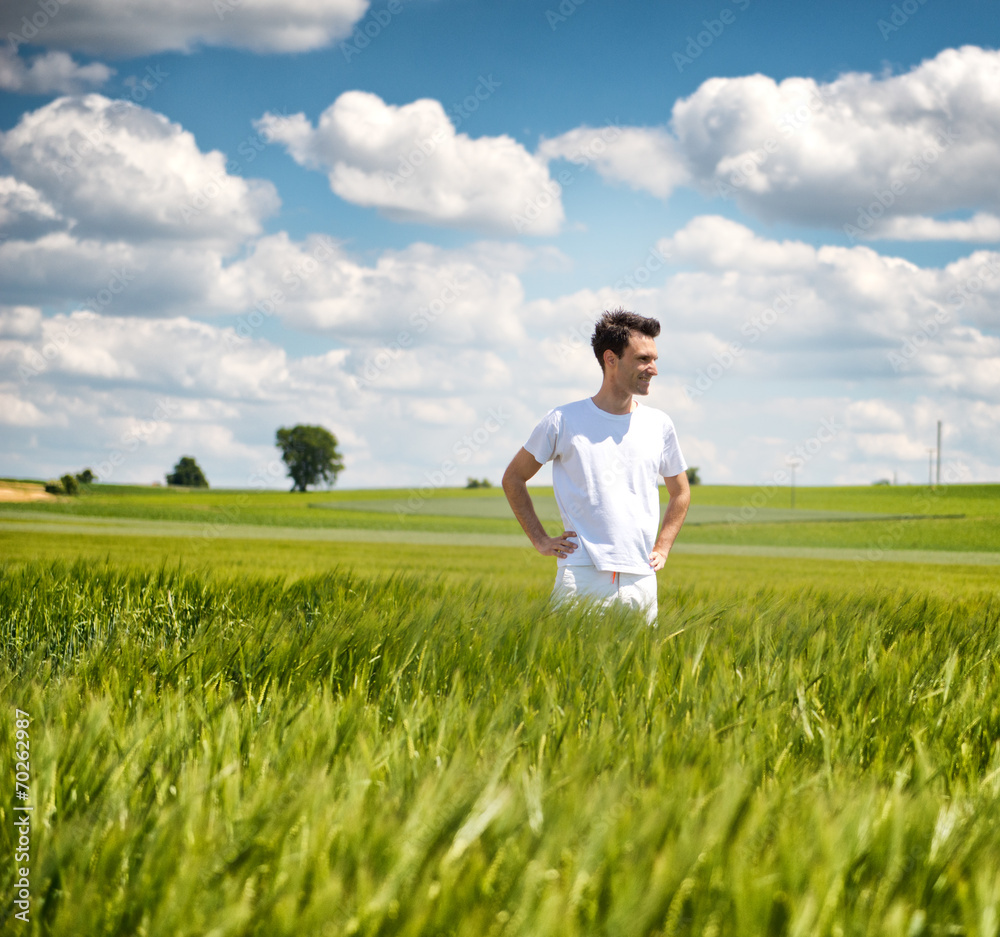 Man standing in a field of young wheat Man standing in a field of young wheat