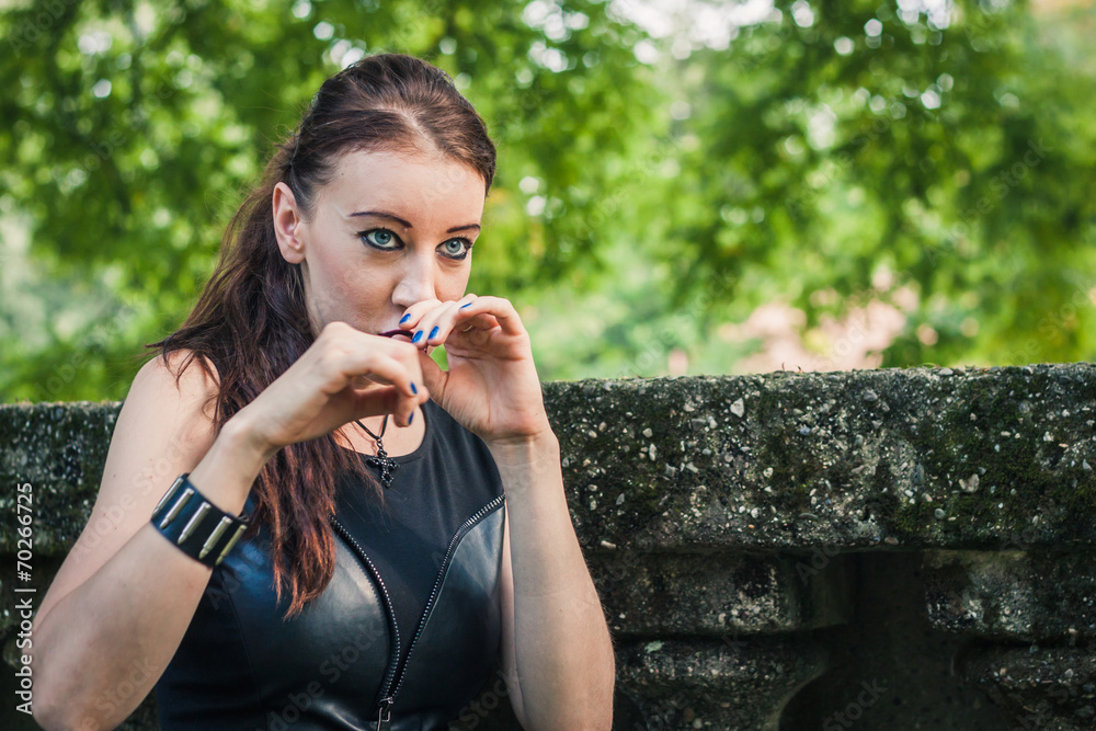 Fototapeta premium Pretty goth girl posing in a city park