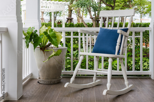 white wooden rocking chair on front porch at home photo