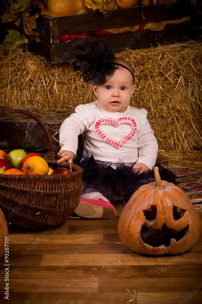 Fototapeta premium little baby girl on Halloween party with pumpkin