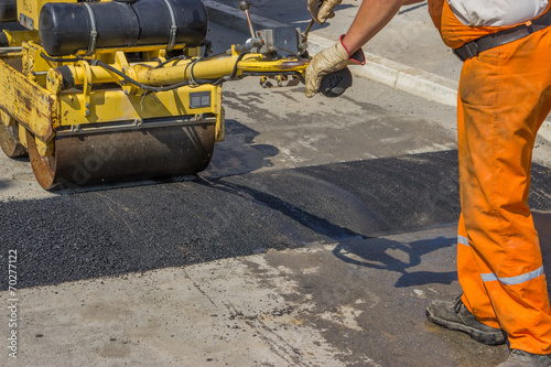 Worker installing asphalt speed bump