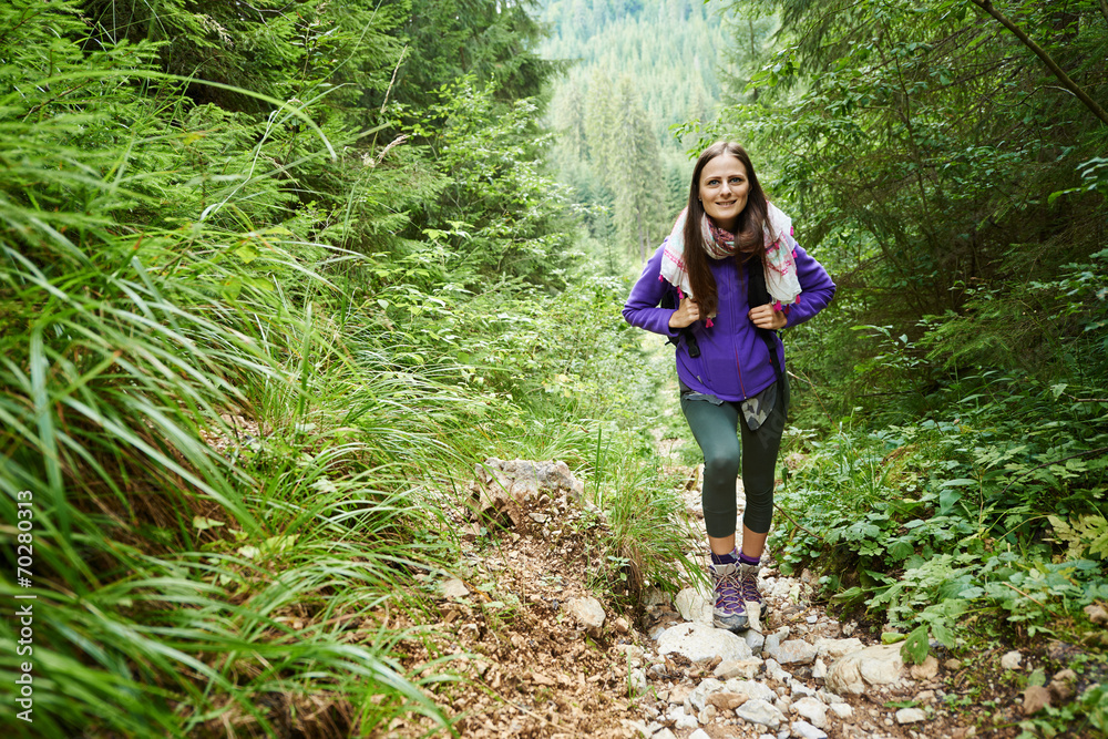 Woman with backpack hiking into the forest