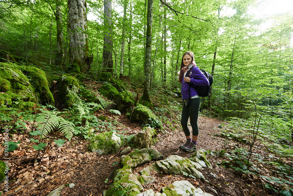 Fototapeta premium Woman with backpack hiking into the forest