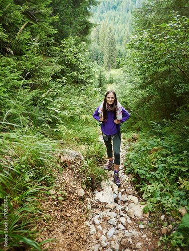 Woman with backpack hiking into the forest