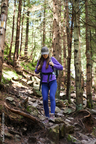 Woman with backpack hiking into the forest