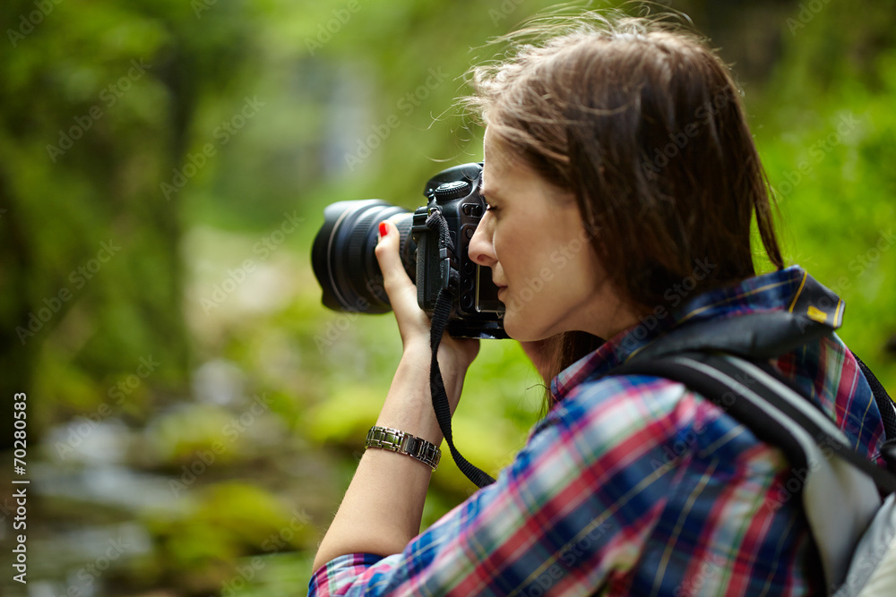Tourist girl taking photos of landscape