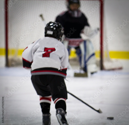 Child playing ice hockey on a breakaway