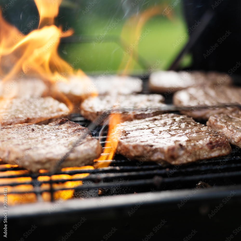 grilling hamburgers on charcoal grill with flames Stock Photo Adobe Stock