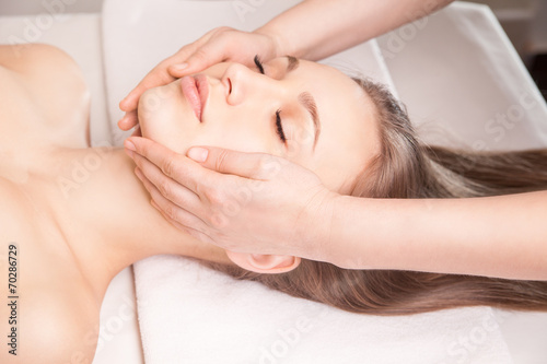 Young bright woman receiving head massage
