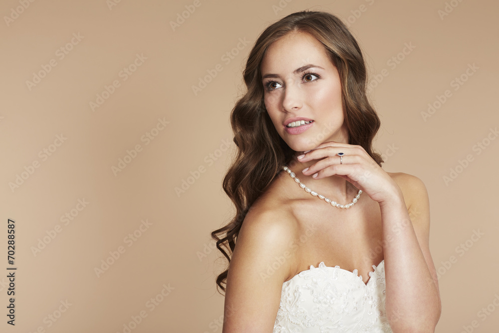 Young bride in wedding dress looking away, studio shot . Young bride in wedding dress looking away, studio shot .