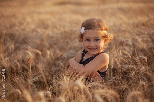 Smiling little girl on the wheat field