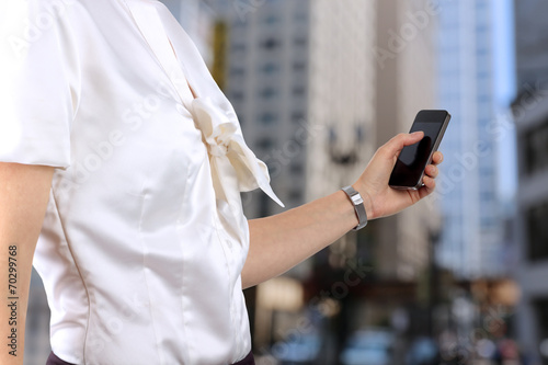 Businesswoman holding and using the mobile smart phone