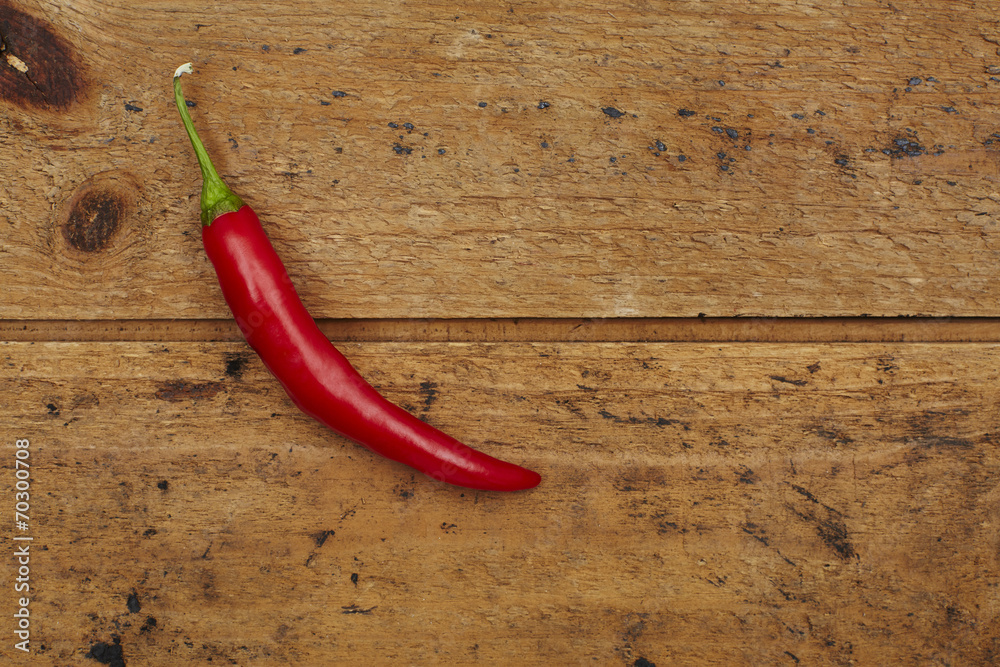 Red chili pepper against wooden background. Red chili pepper against wooden background.