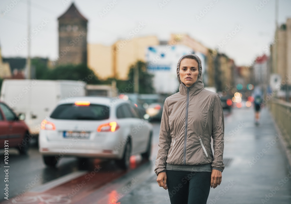 Portrait of fitness young woman in rainy city