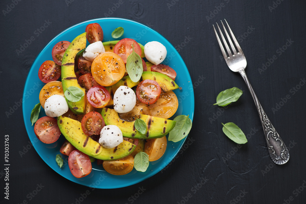Vegetable salad with grilled avocado and basil, above view Vegetable salad with grilled avocado and basil, above view