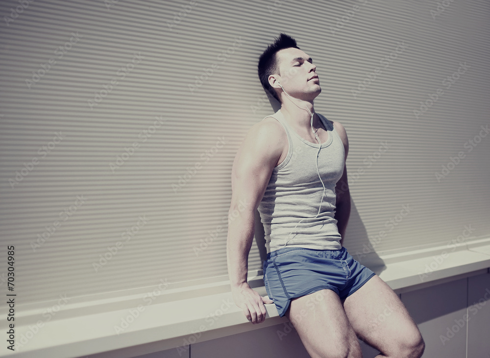 Obraz premium Handsome man resting after training listening to music on headph