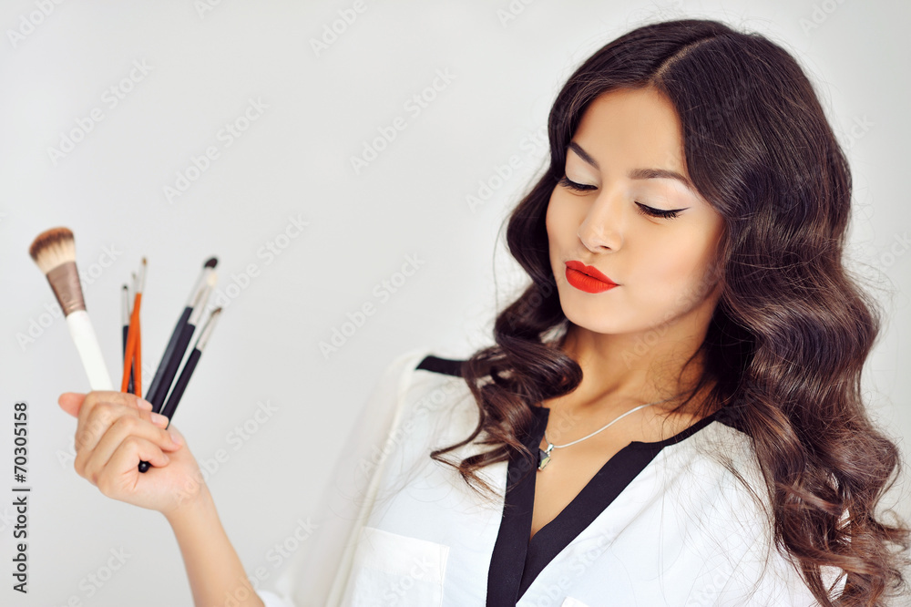 Beautiful woman with makeup brushes near her face Beautiful woman with makeup brushes near her face