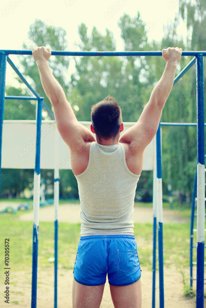 Fototapeta premium Workout sports man pull up on the horizontal bar