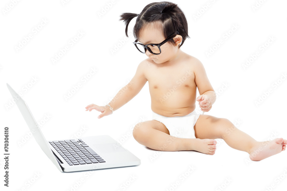 Naklejka premium little child sitting playing on a laptop. isolated on white