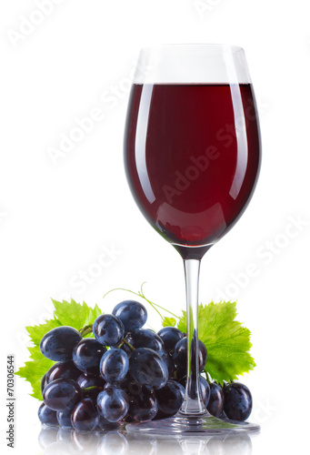 Glass of red wine with bottle and ripe grapes isolated