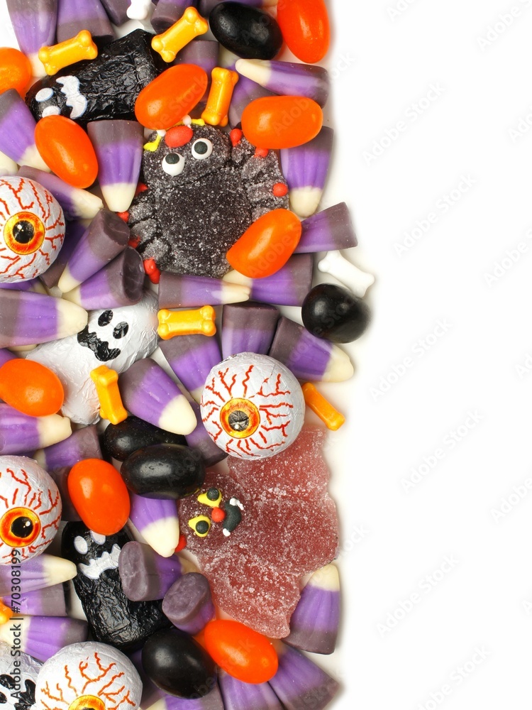 Vertical Halloween candy border over a white background