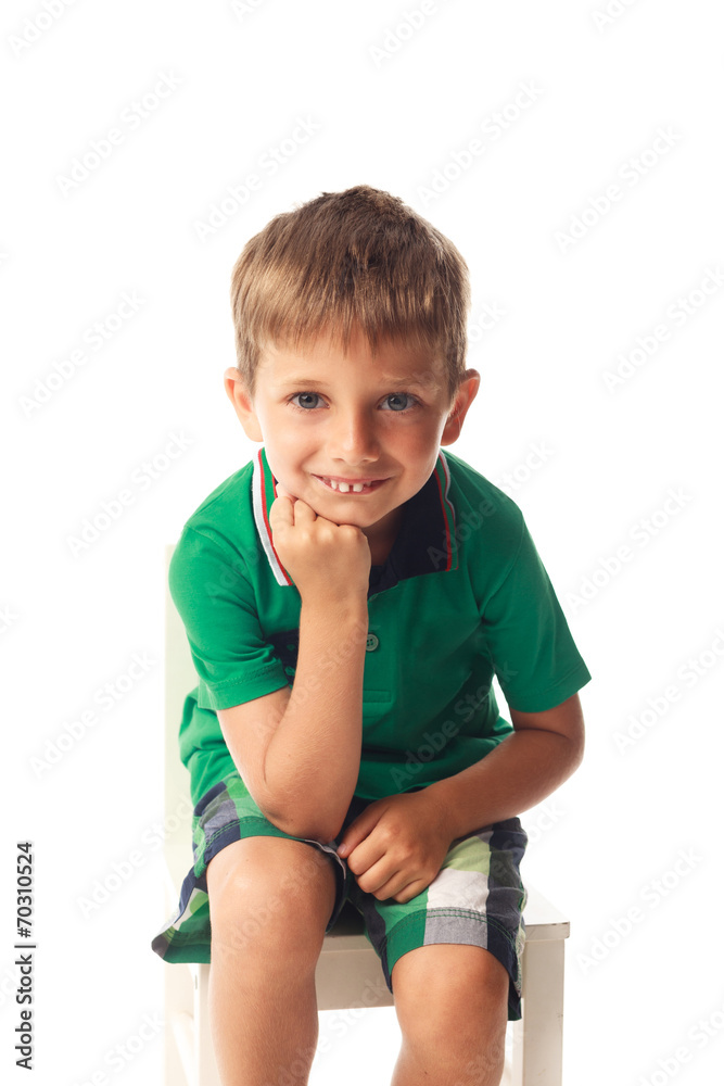 Little smiling boy on chair isolated on white