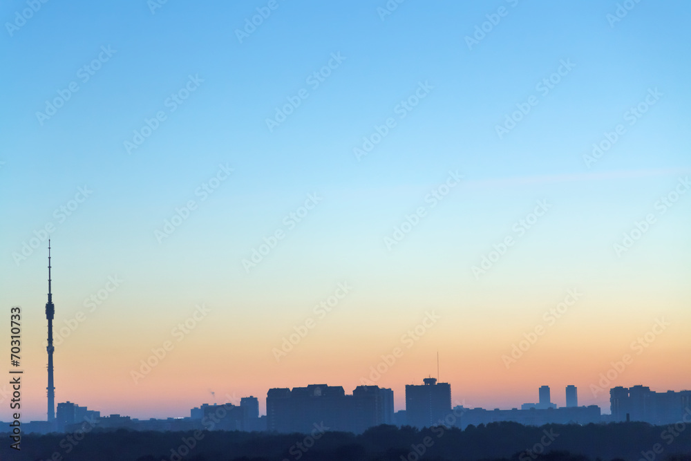 clear blue and yellow daybreak sky over city