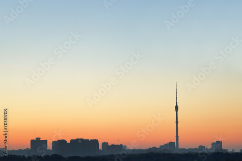 clear blue and yellow sunrise sky over city